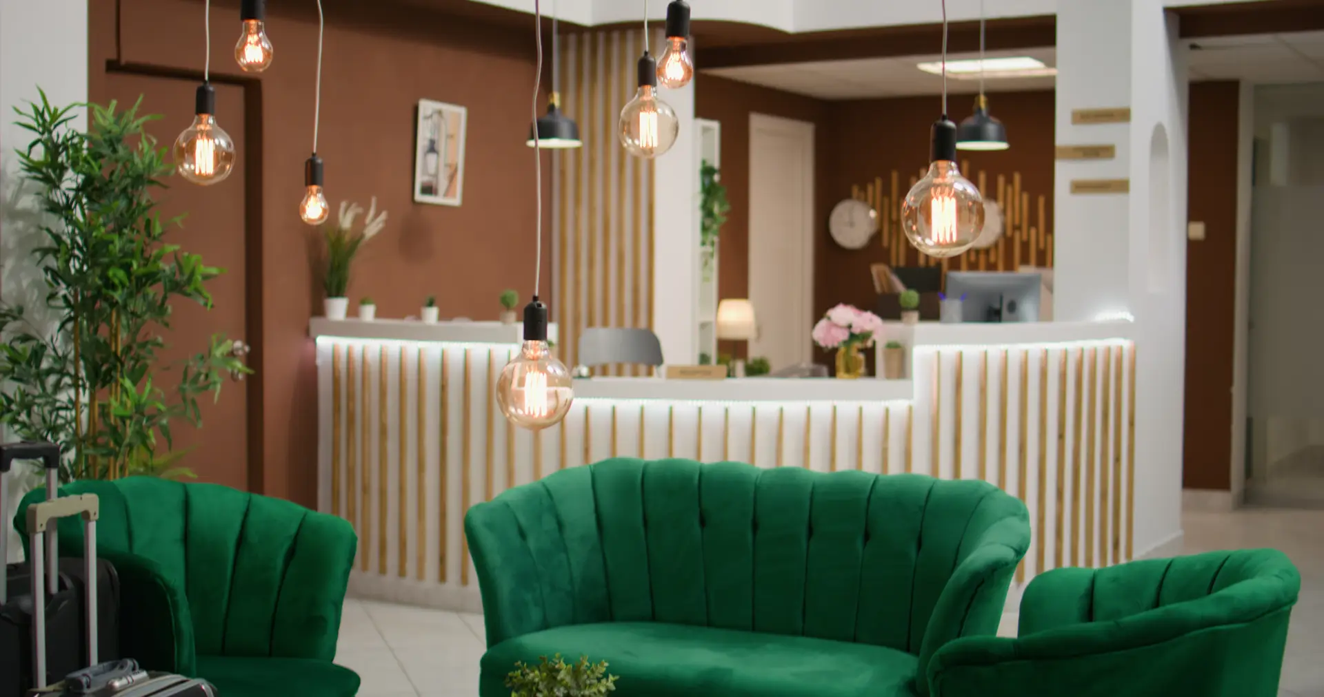 Hotel lobby with reception desk, pendant lighting and lounge seating